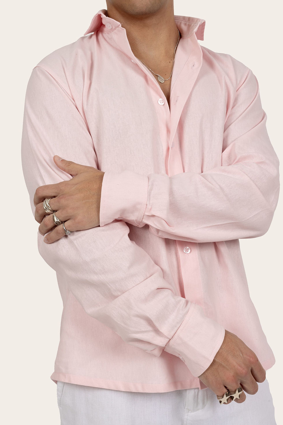 Miniatura: Homem de camisa rosa, com braços cruzados, Melanina, em fundo bege.