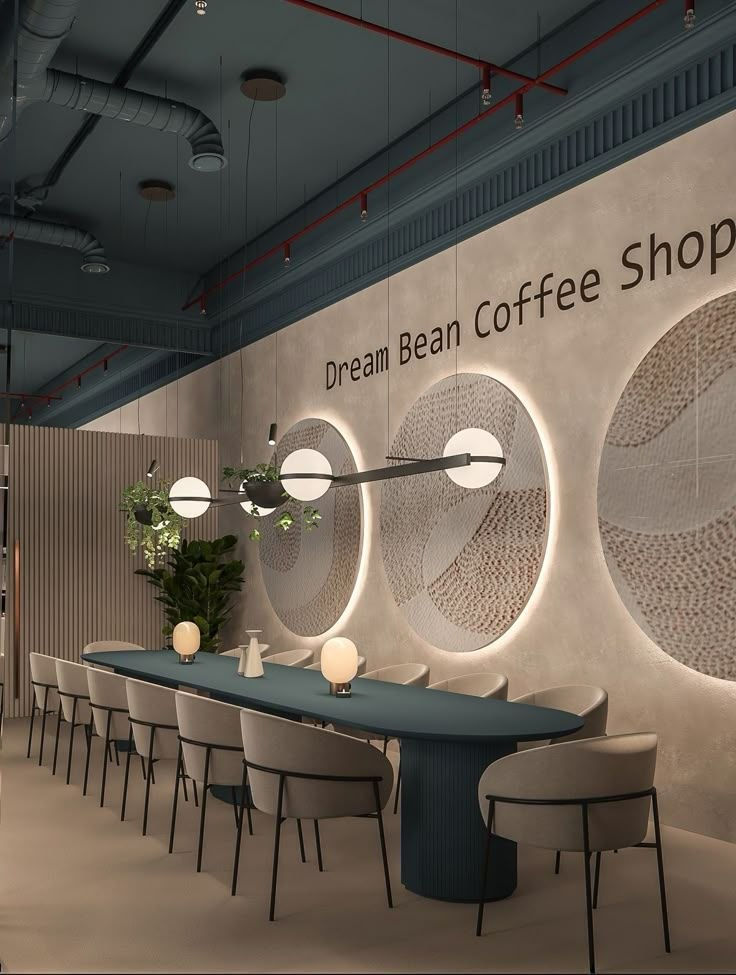 مقهى عصري فارغ بطاولات وكراسٍ بيج، جدار مزخرف وإضاءة دائرية، ونص Dream Bean Coffee Shop على الحائط.