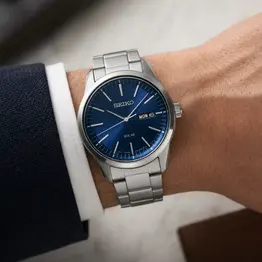 SEIKO Solar Uhr mit blauem Zifferblatt und Edelstahlband am Handgelenk als Symbolbild für die Kategorie Solar.