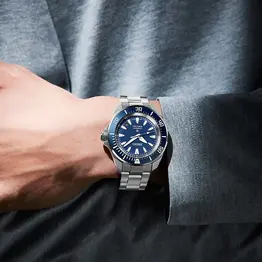 Seiko Slim Samurai Diver’s mit schwarzem Zifferblatt und Edelstahlband in stilvoller dunkler Inszenierung.