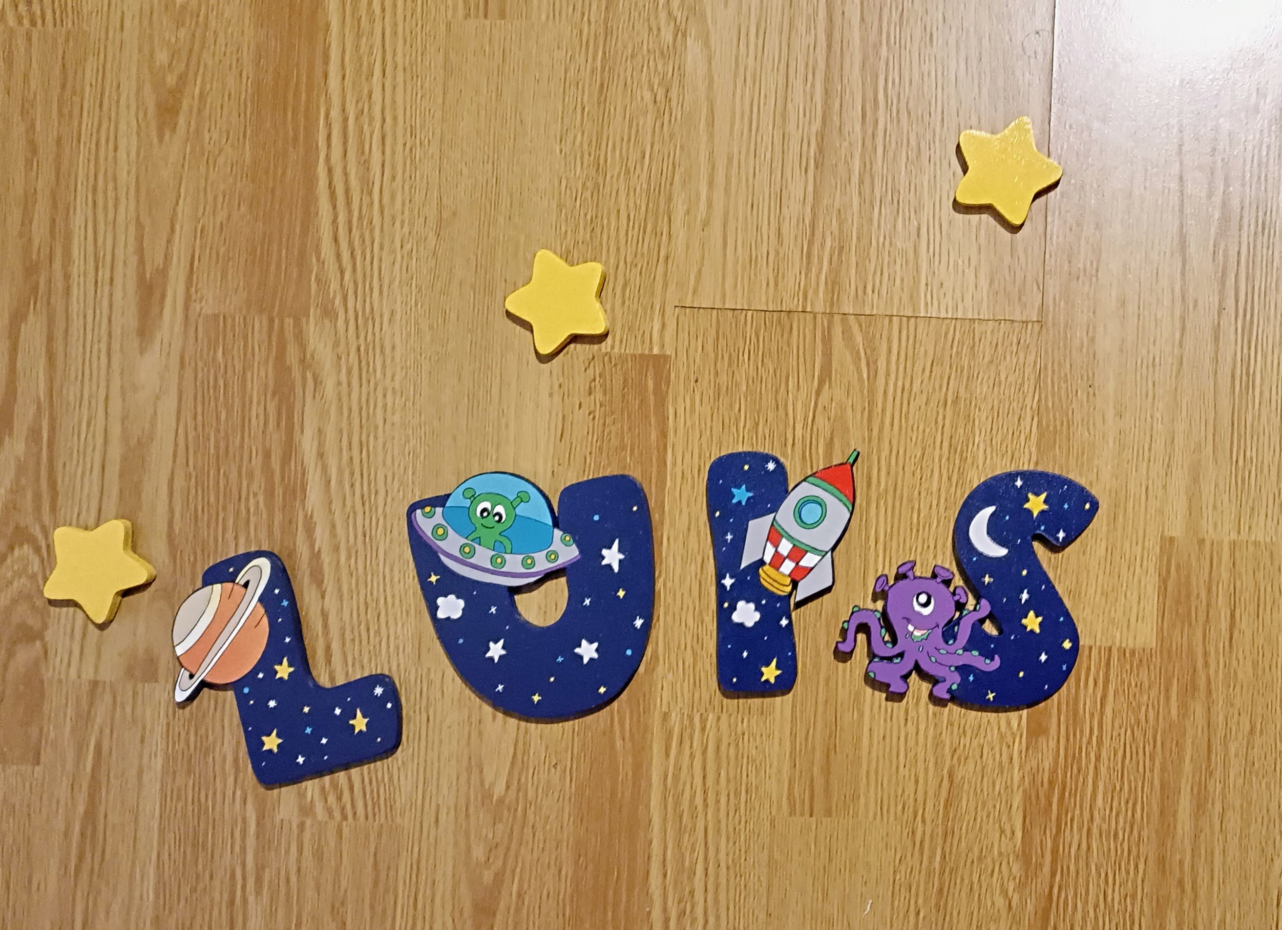 Les lettres du prénom LUIS en bois décorée sur le thème de l'espace de couleur bleu nuit