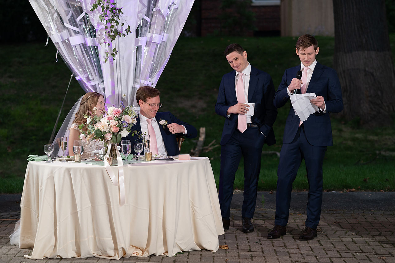 candid photo of couple laughing during wedding speeches at reception