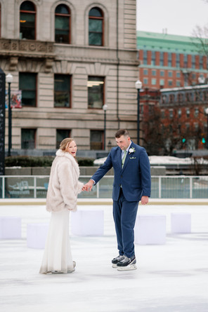 wedding couple ice skating on worcester city hall oval rink for winter wedding