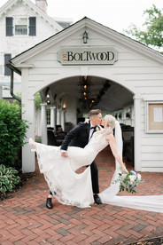 couple in romantic dip in front of inn on boltwood sign