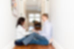 engagement in home session with couple sitting in hallway having a thumb wrestling war