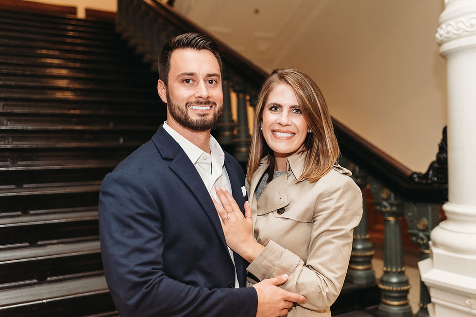 newly engaged couple smiling and posing for camera in Austin Capitol building