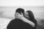black and white photo of couple embracing with hand on back of head to clearly show new engagement ring