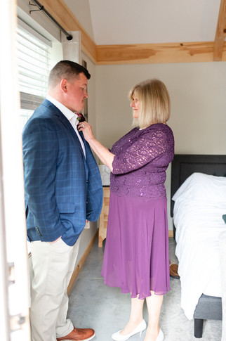 groom's mom pinning on his boutonniere