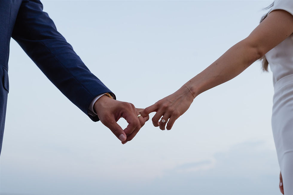 couple holds fingers loosely to show off their wedding rings
