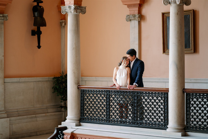 couple snuggling on balcony for wedding photos
