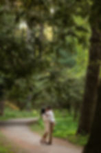 couple kissing on path between tall trees at doyle conservation area