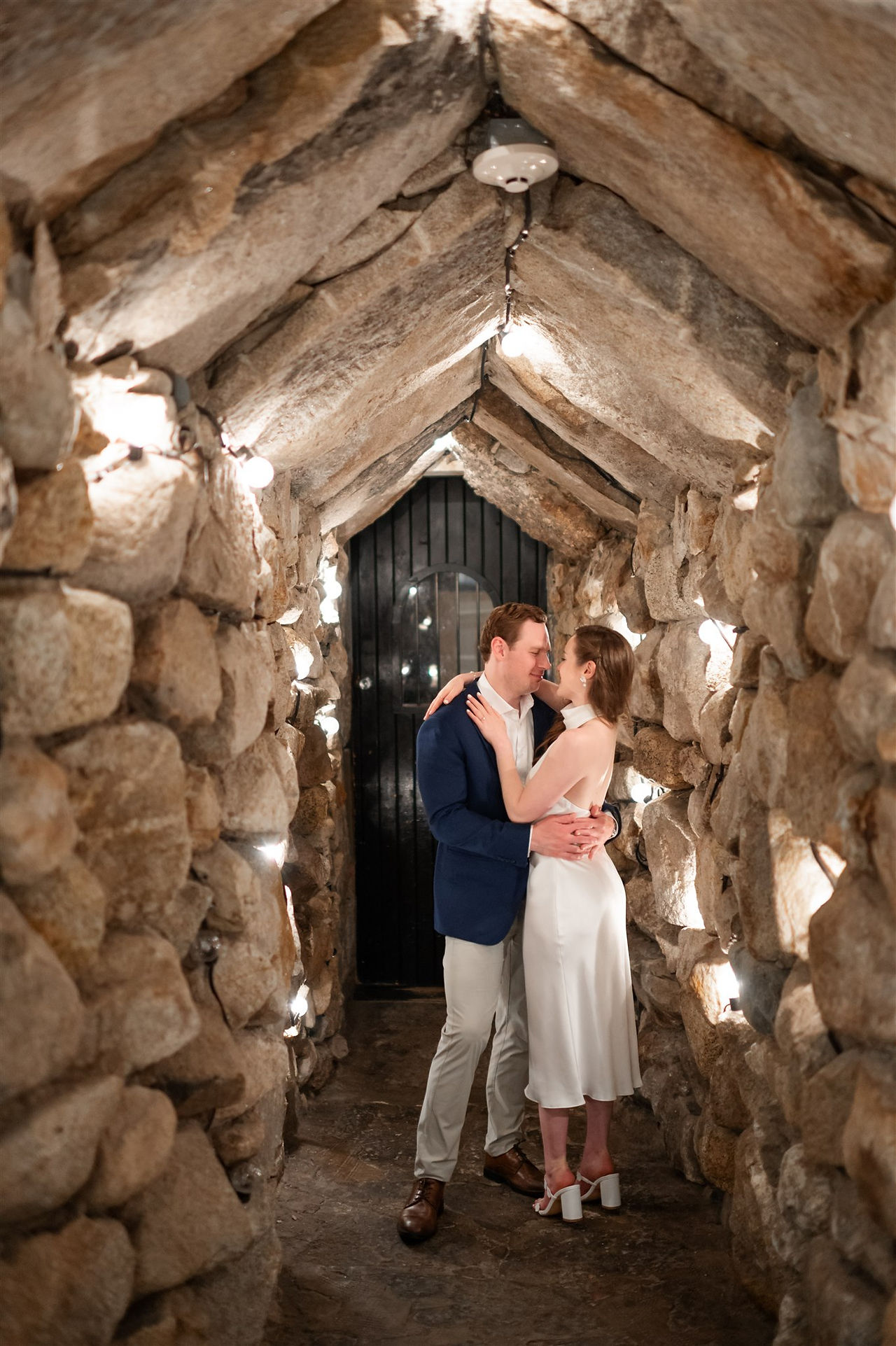 couple posing for photo in "the cave" at omni mount washington resort during rehearsal dinner