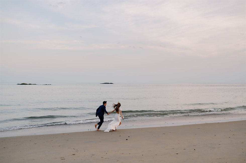 couple running along the beach hand in hand during sunset