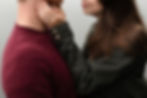 cut in half, close up photo of girls hand on guys face with engagement ring in focus