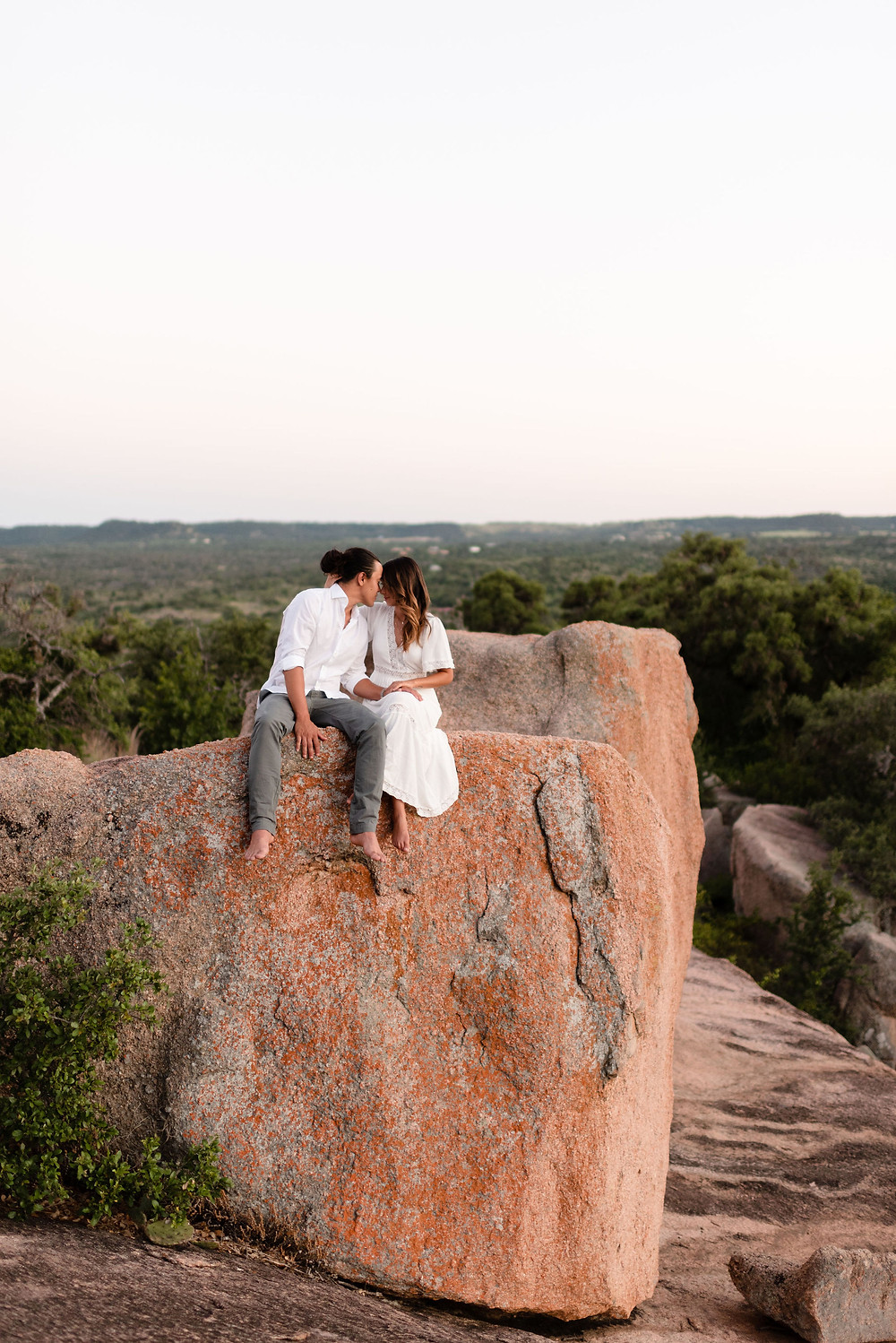 couple sitting on rock together at enchanted rock
