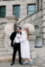 couple standing out front of city hall with sunglasses on