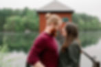 couple looking at each other in front of lake and water treatment facility at middlesex fells reservation