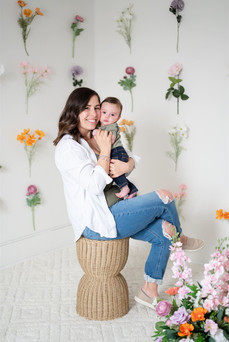 family photo in studio with flowers hung up on wall