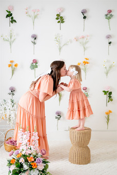 family photo in studio with flowers hung up on wall