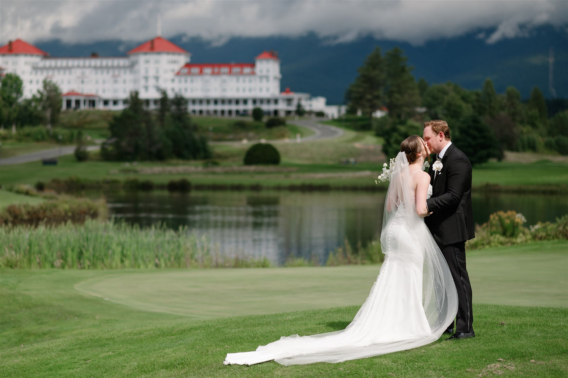 bride and groom kissing with omni mount Washinginton in the background