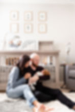 in home newborn session with couple sitting by crib