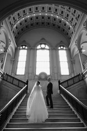 black and white photo of wedding couple ascending grand staircase at worcester city hall