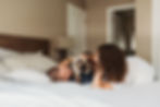 in home engagement session couple lays on the bed with a cat