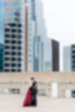 a couple in formal attire on the roof of a parking garage in downtown austin texas for their engagement photos