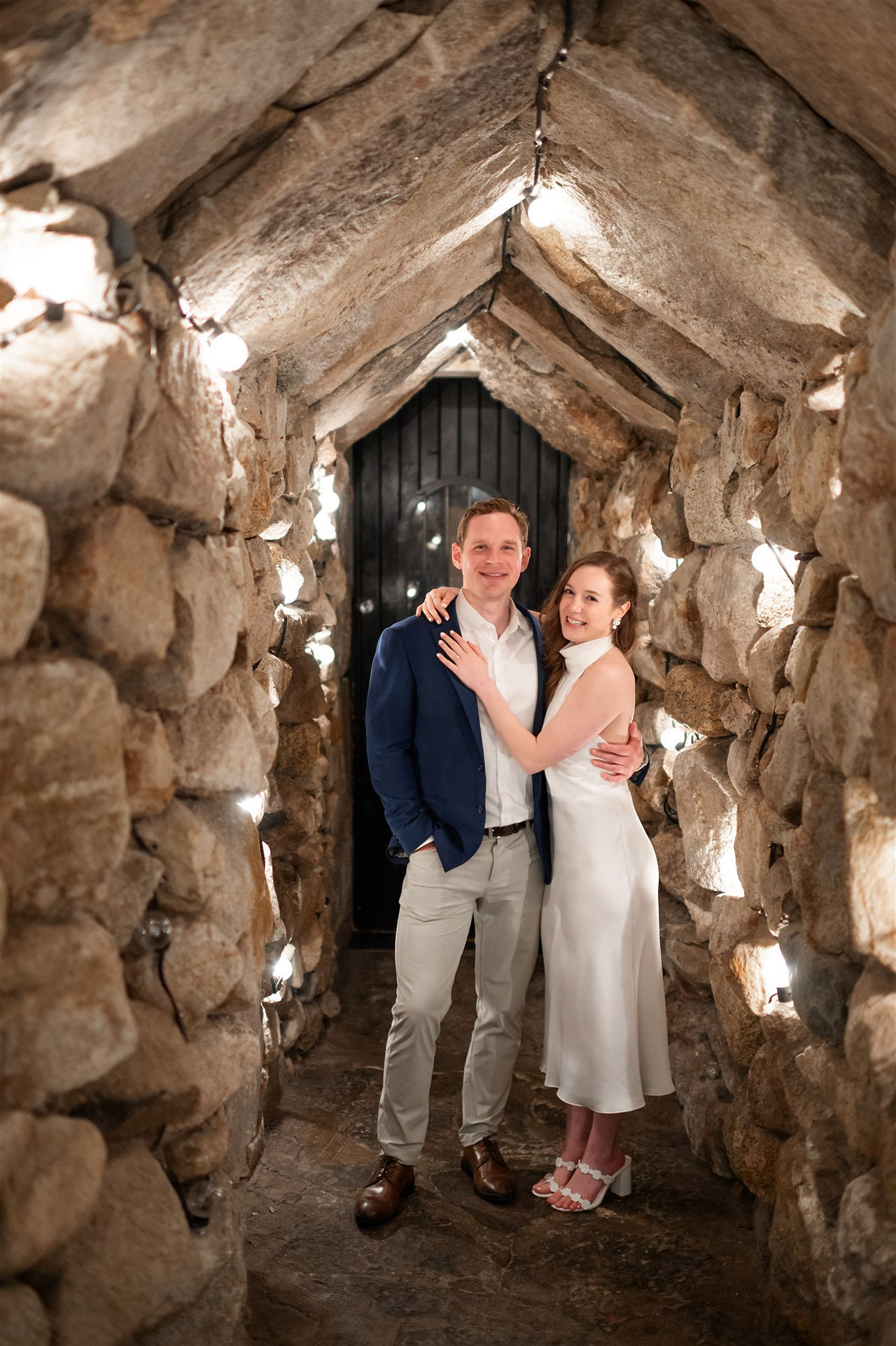 couple posing for photo in "the cave" at omni mount washington resort during rehearsal dinner
