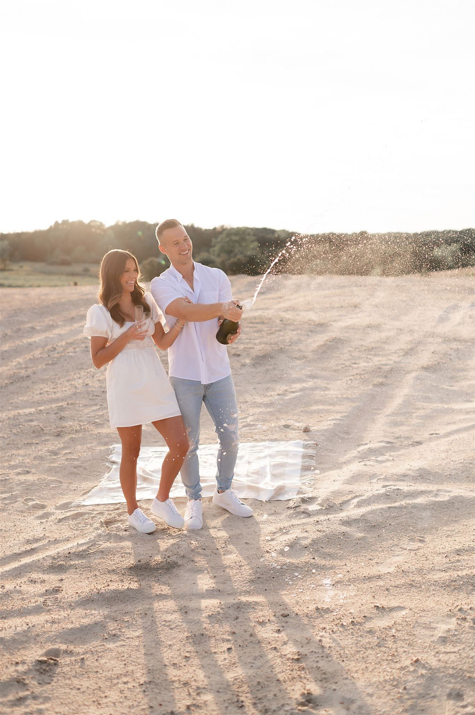 popping champagne during engagement session
