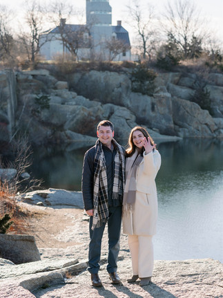 girl showing off her new engagement ring smiling at the camera at Halibut Point state Park