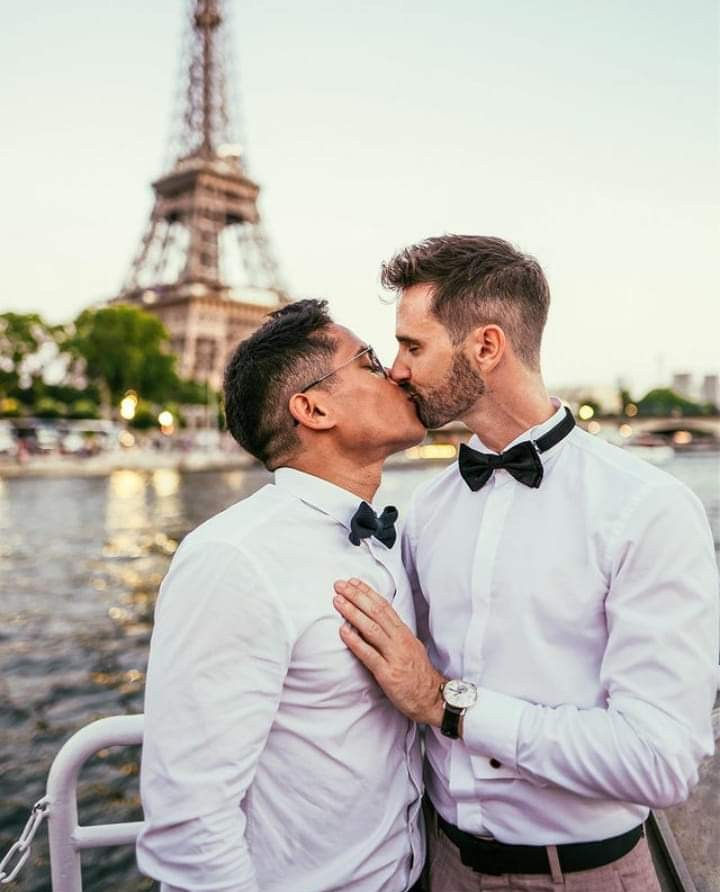 Two men kissing in front of the Eiffel Tower in Paris, illustrating connection, intimacy and Gay Tantra in the French Neo-Tantra tradition.