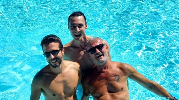 Trois participants souriants dans une piscine pendant un stage de Tantra pour hommes organisĂ© par CĆurs dâhommes.