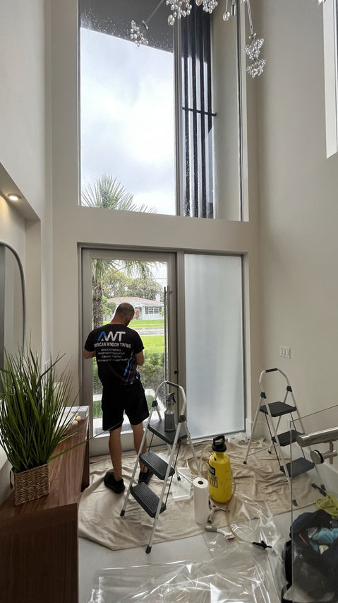 Front door glass frosted film installation in progress. AWT American Window Tinting, Delray Beach.