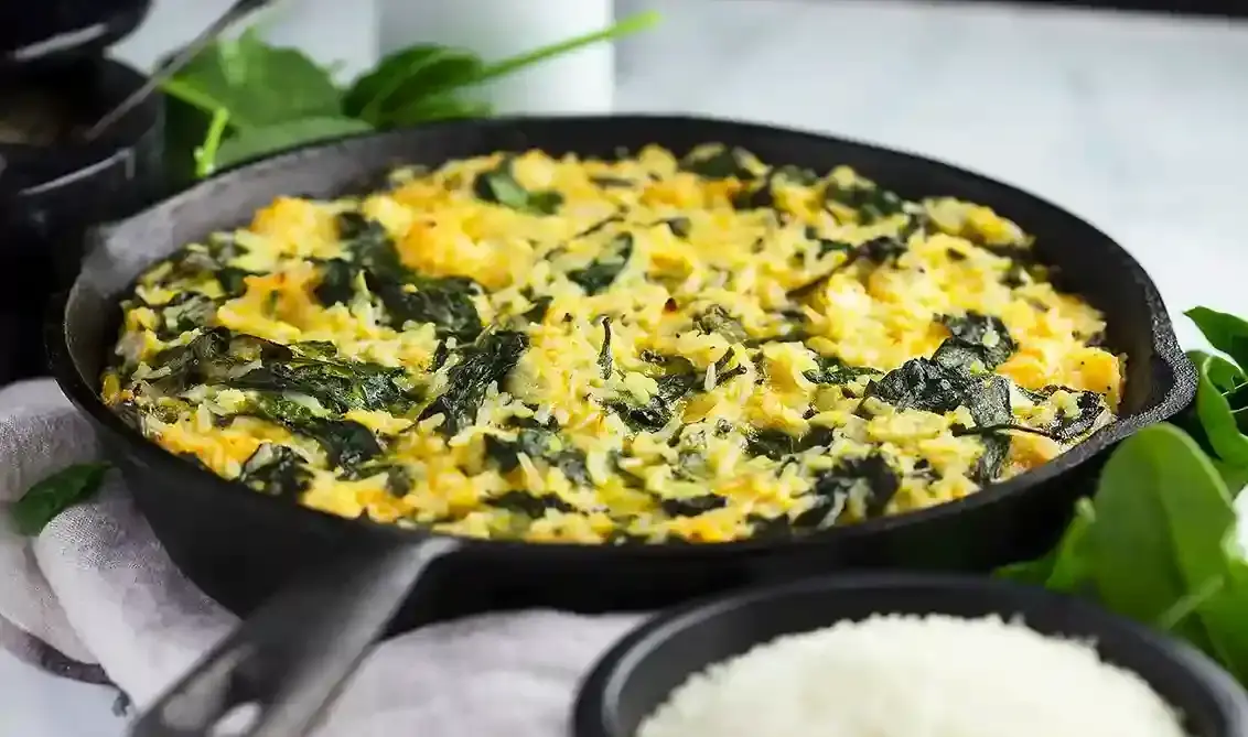 Baked rice dish with spinach in a skillet