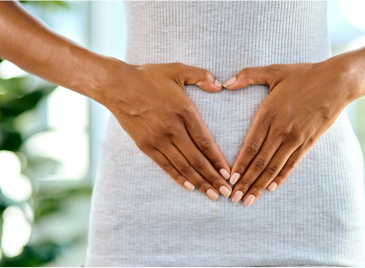 Hands in a heart shape over stomach