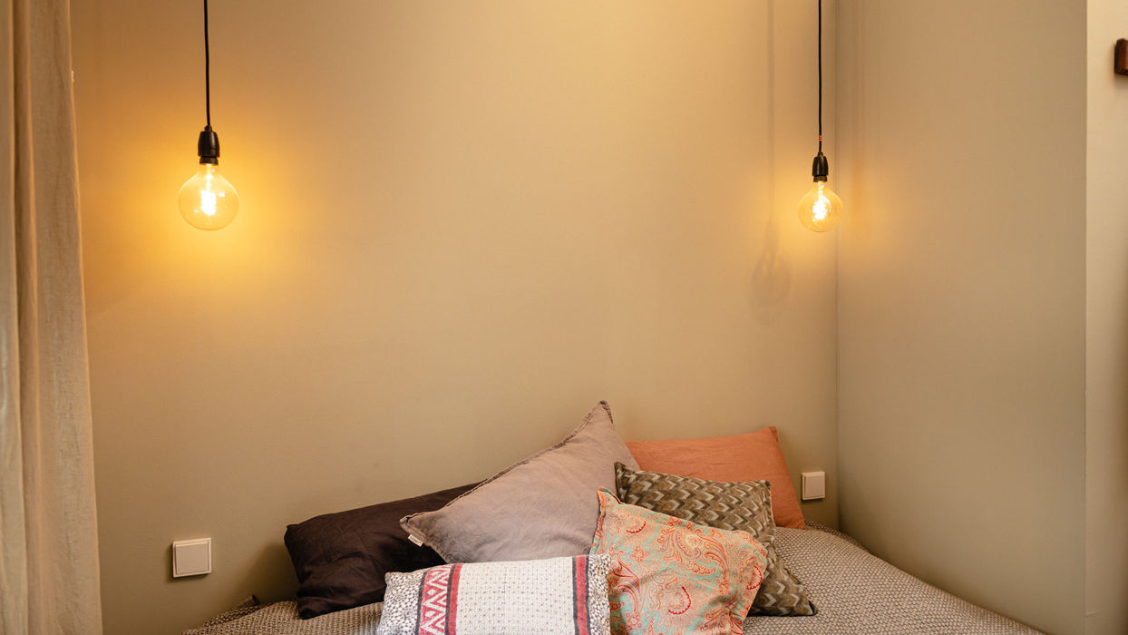Gemütlicher Ruheraum mit Bett und warmer Lichtstimmung im Praxisraum