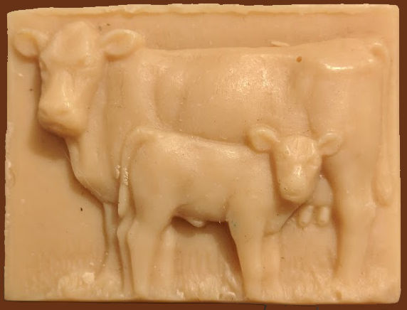 A rectangular bar of soap with the raised image of a cow with her calf standing at her side.