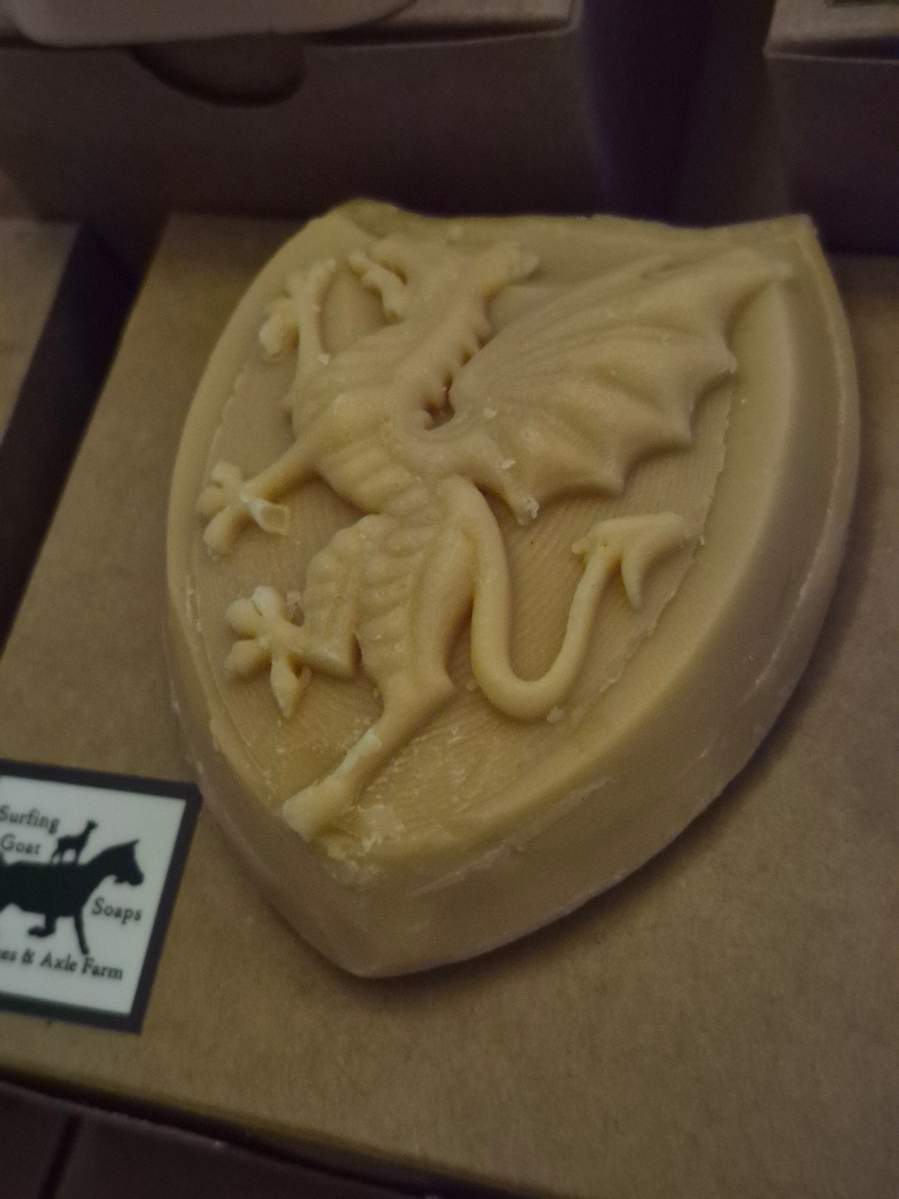 A handful of soap, shaped like a shield, with a dragon on the front.