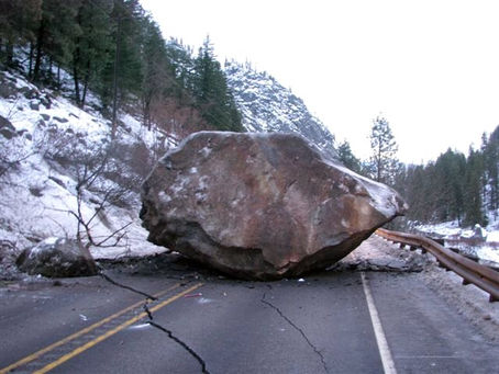 A very large rock blocking a road