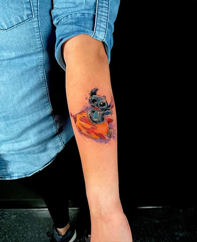 Heather Santistevan's Whimsical Watercolor Lilo & Stitch Tattoo: Friendship and Adventure Illustrated in Vibrant Ink at United Tattoo