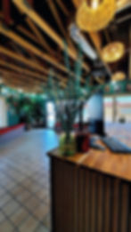 The front desk and waiting area at The Glory Hole Piercing Studio, showcasing a modern, clean space with bohemian décor and a welcoming atmosphere.