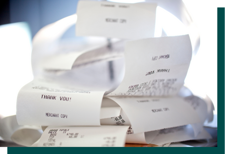 A pile of printed sales receipts, some marked “Merchant Copy” and “Thank You,” symbolizing retail transaction volume.
