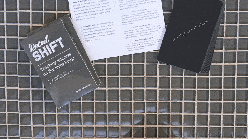 Animated GIF of hands dealing displaying three Retail Shift training cards, one at a time. The card box and instruction booklet is visible in the background.