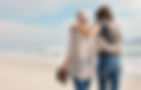 a daughter and older mother walking the beach