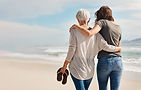 a daughter and older mother walking the beach