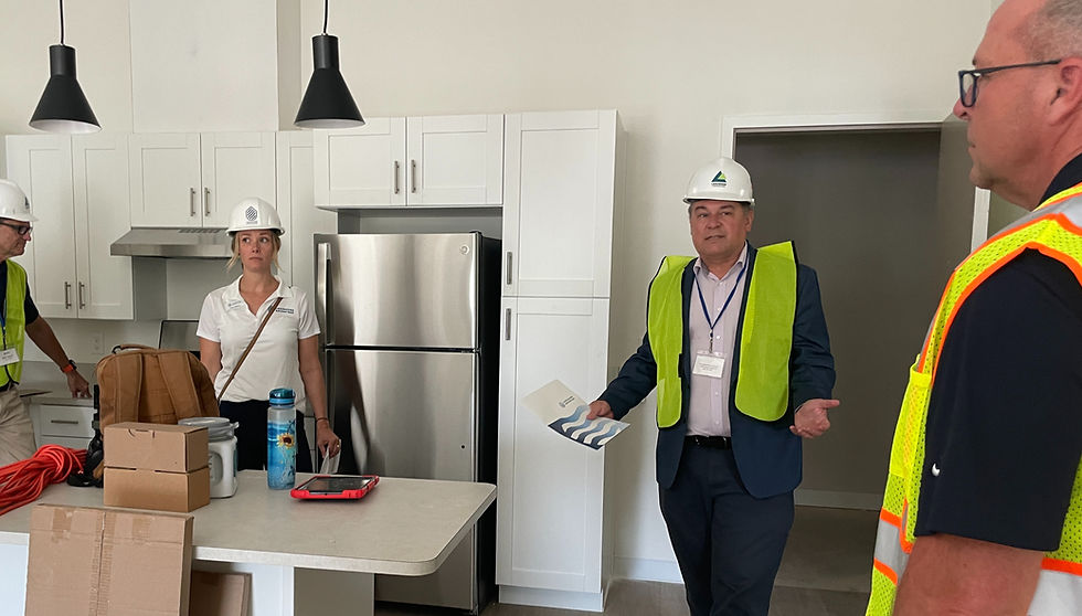 Seth Haron of Magnus Capital Partners explains the amenities in a HoM flats unit kitchen