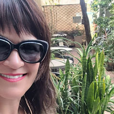 Nádia lendo o livro "Subversivas" no quintal do Moa Café