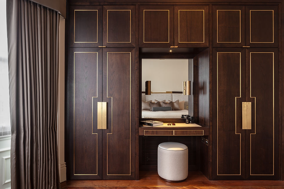 Custom wardrobe and vanity unit in dark wood with brass inlay, bespoke joinery design by Cochrane Bespoke for a high-end London bedroom.