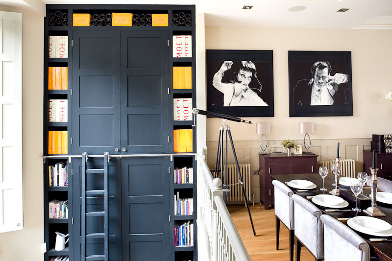 Bespoke black joinery with built-in shelving and ladder designed by Cochrane Design, adding architectural drama to a London dining space.